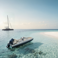 Zodiac Yachtline 4.0 luxe RIB tender bij strand met jacht op helder blauw water